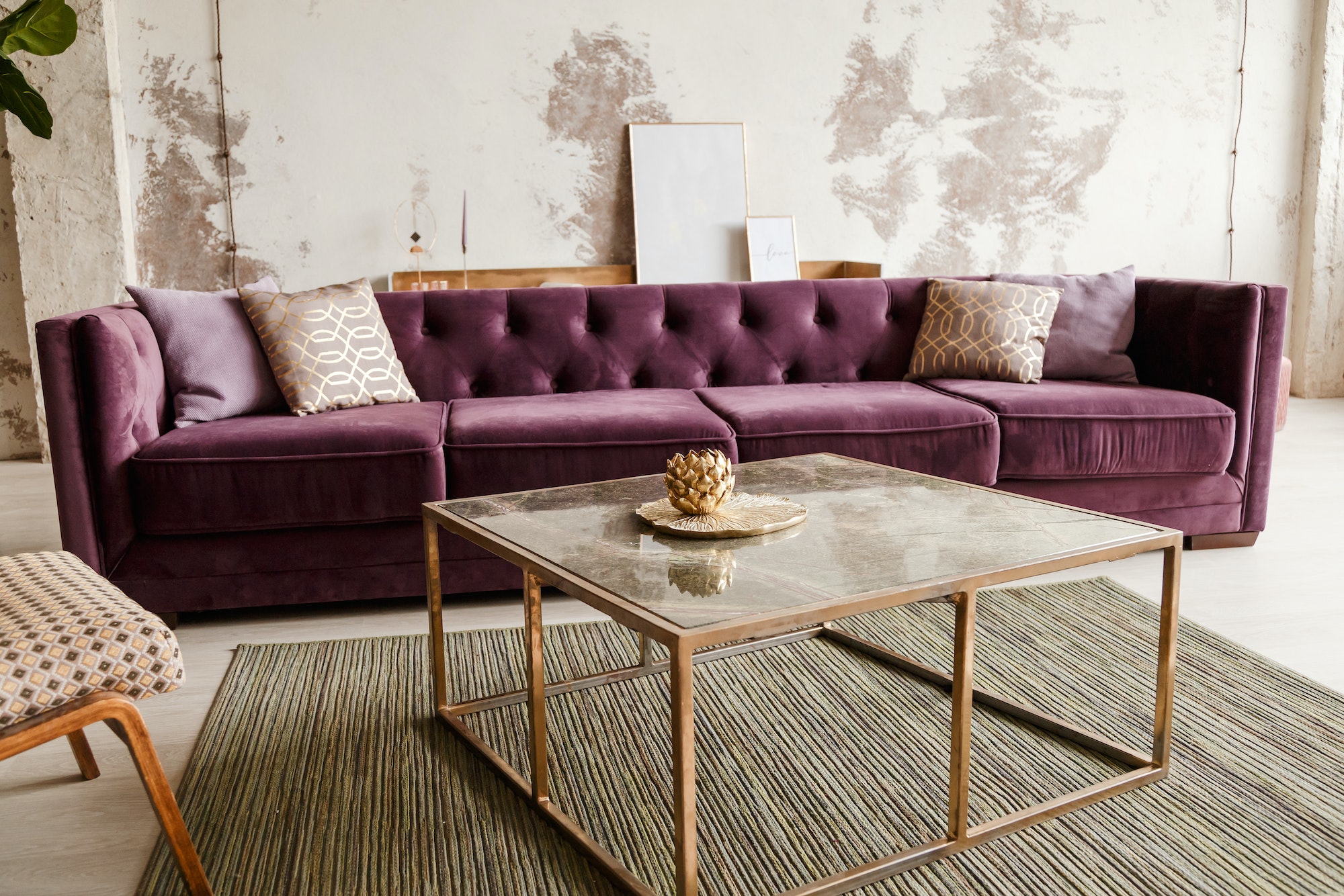 Purple velvet sofa with golden pillow in living room interior